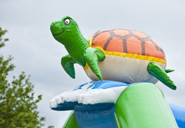 Opblaasbaar overdekt multiplay multifun springkasteel met glijbaan kopen in thema schildpad turtle voor kinderen. Bestel springkussens online bij JB Inflatables Nederland