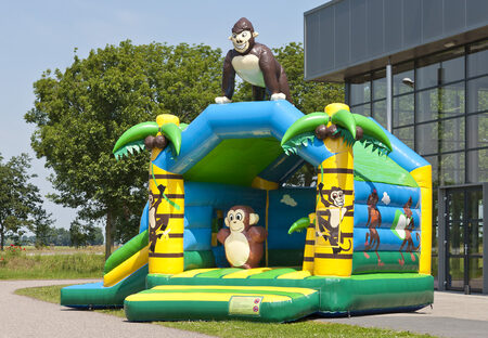Opblaasbaar overdekt multifun springkussen met glijbaan bestellen in jungle thema met een 3D object van een gorilla voor kinderen. Koop springkussens online bij JB Inflatables Nederland